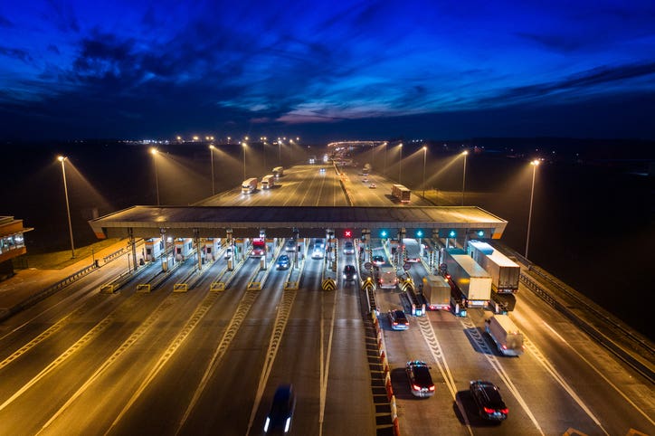 Aerial drone view on toll collection point on motorway at night. A pay road.