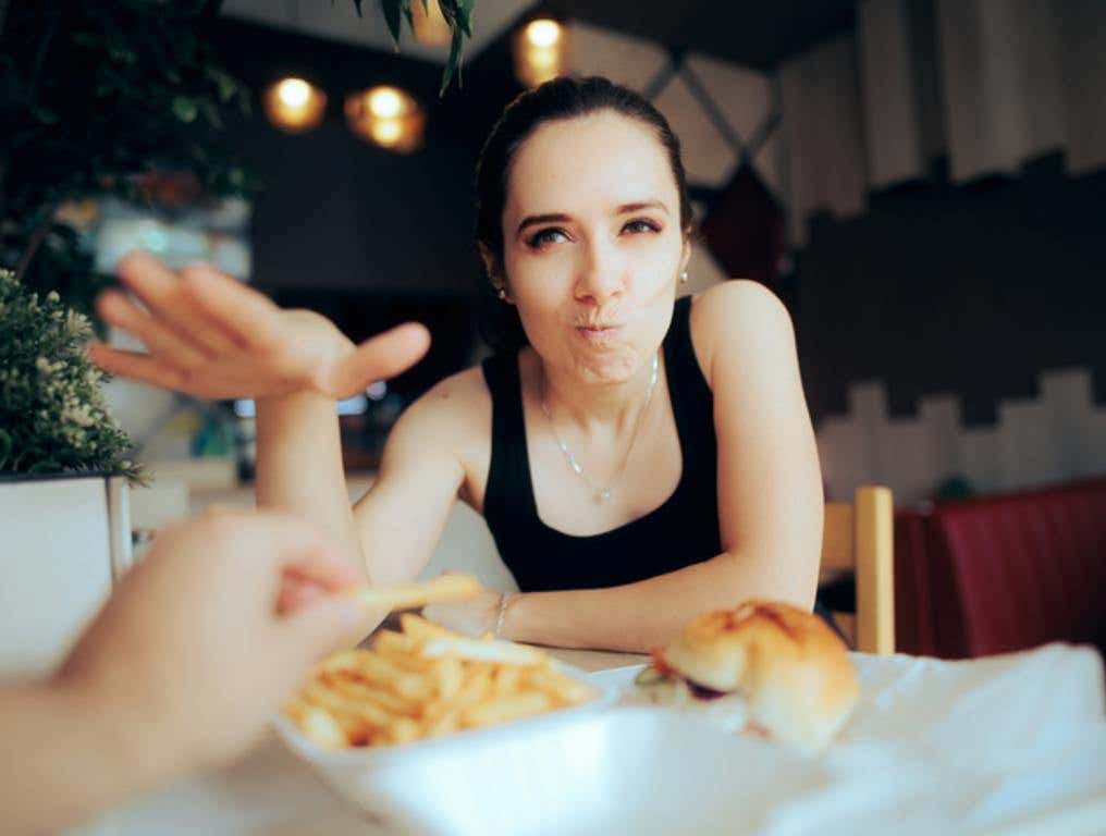 Boyfriend Stealing French Fries from Unhappy Hungry Girlfriend, foods we don't want to share ocncept.