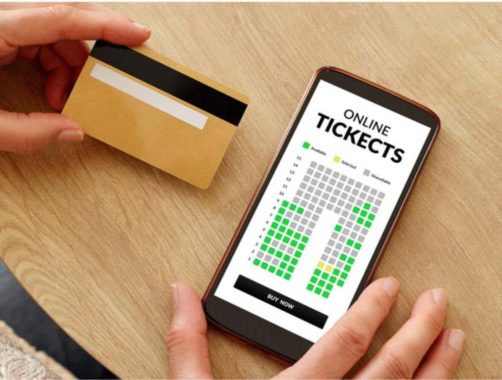 Close-up photo of female hands with credit card making mobile payment for event cinema tickets. Online show theater tickets booking., live event tickets concept.