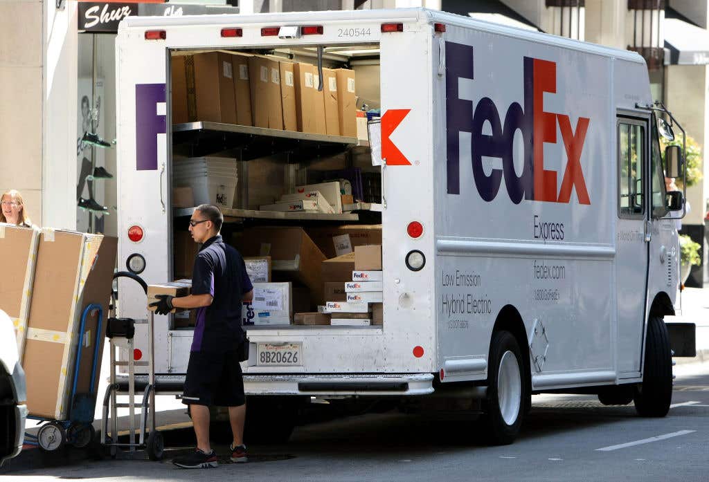 FedEx truck with delivery driver moving boxes. Fort Myers Porch Pirate Wanted For Stealing New iPhones From Homes