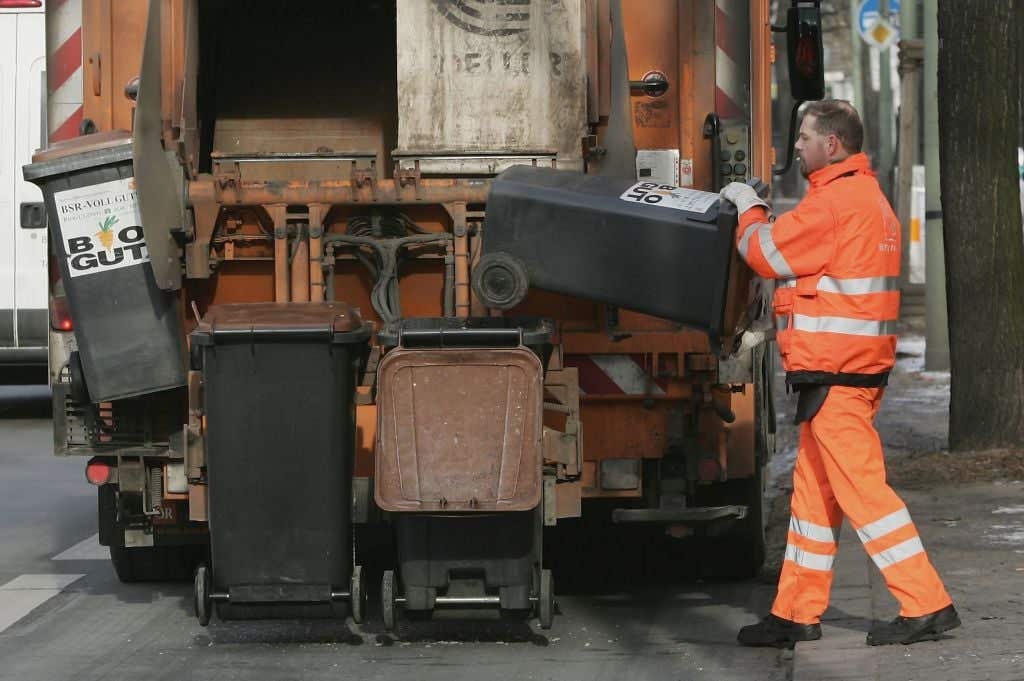 Garbage collector collecting trash with a garbage truck. Great Debate: Should You Tip Your Garbage Collectors?