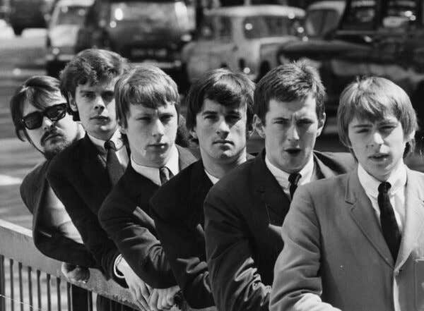 A black and white picture of English band, The Yardbirds leaning on a railing. (L-R) Manager Giorgio Gomelsky, Paul Samwell-Smith, Chris Dreja, Jim McCarty, Eric Clapton and Keith Relf, circa 1965.