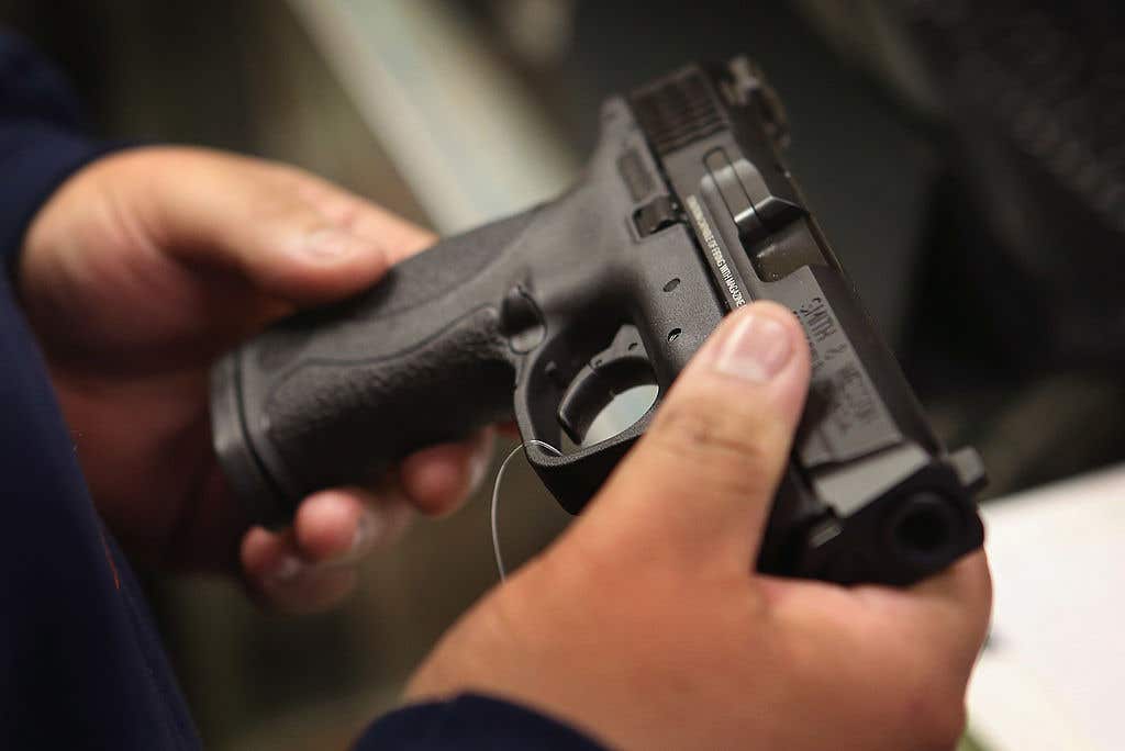 Man holding and examining a gun