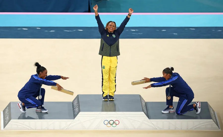 Gold medalist Rebeca Andrade (C) of Team Brazil, silver medalist Simone Biles (L) of Team United States and bronze medalist Jordan Chiles (R) of Team United States celebrate on the podium at the Artistic Gymnastics Women's Floor Exercise Medal Ceremony, a top Olympic moment