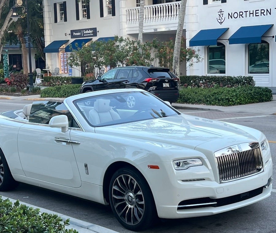 White convertible Rolls-Royce parked on a street 