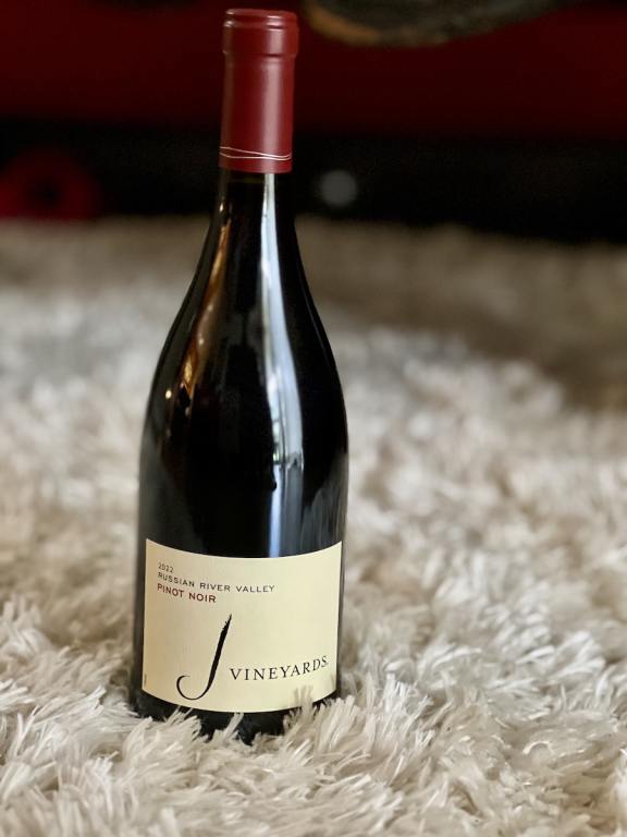 Bottle of J Vineyard Pinot Noir on a white shag rug