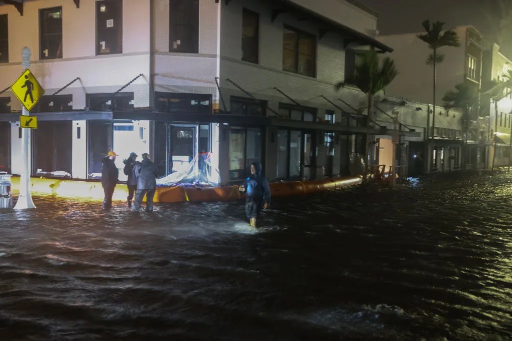 Members of the media work in flooded streets after Hurricane Milton made landfall in the Sarasota area on October 09, 2024, in Fort Myers, Florida. Milton, coming on the heels of the destructive Helene, hit as a category 3 storm with winds of over 100 mph, though veering south of the projected direct hit on Tampa. Instead, the storm, which earlier had reportedly spawned tornadoes, landed about 70 miles south of Tampa near Siesta Key, a strip of white-sand beaches that's home to 5,500 people, according to published reports.. 