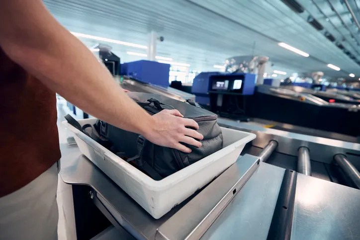 Airport security check. Young man waiting for x-ray control his bag fpr TAirport security check. Young man waiting for x-ray control his bag." with TSA approved food for holiday flying.